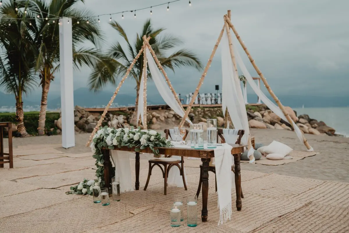 Beachfront wedding reception at Velas Vallarta in Puerto Vallarta, decorated with flowers and bamboo accents.