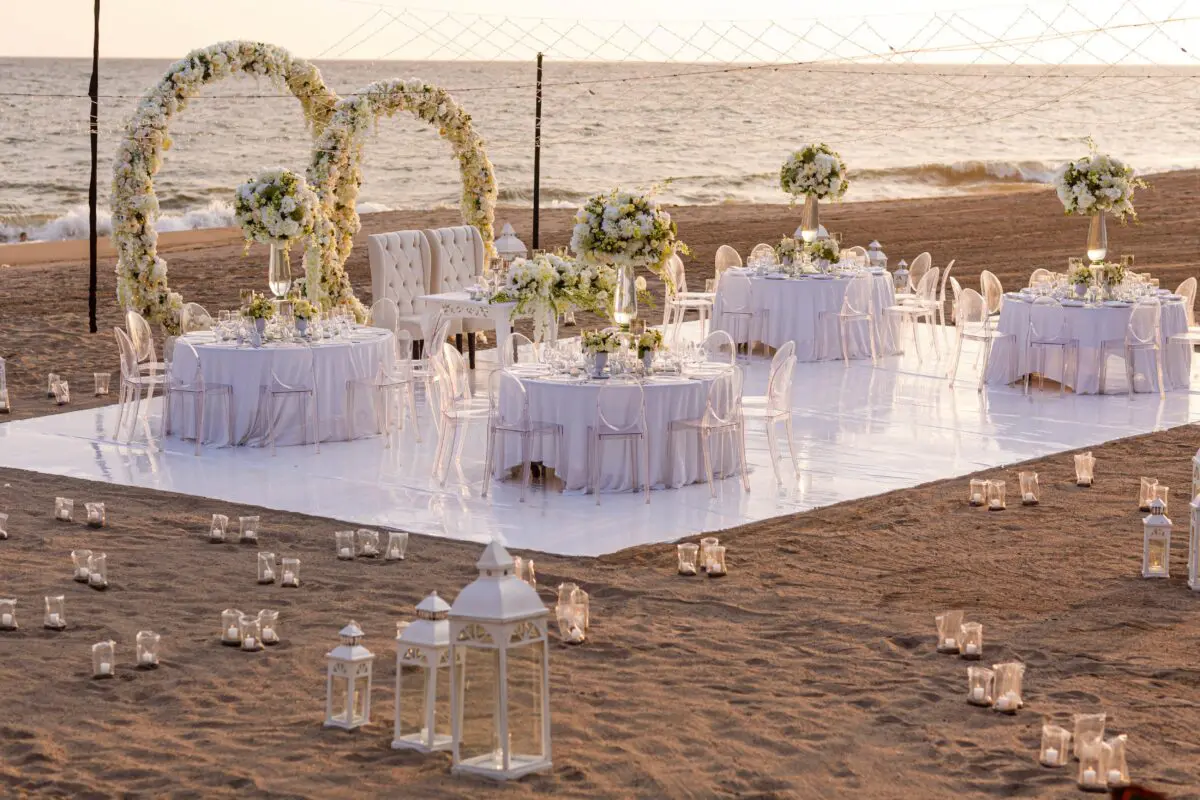 Beach wedding reception at Velas Vallarta in Puerto Vallarta, with floral arches and tables.