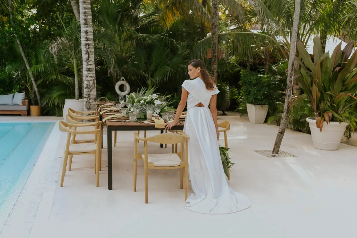 Bride at Jashita Hotel Tulum wedding venue, standing by a beautifully set table near the pool.