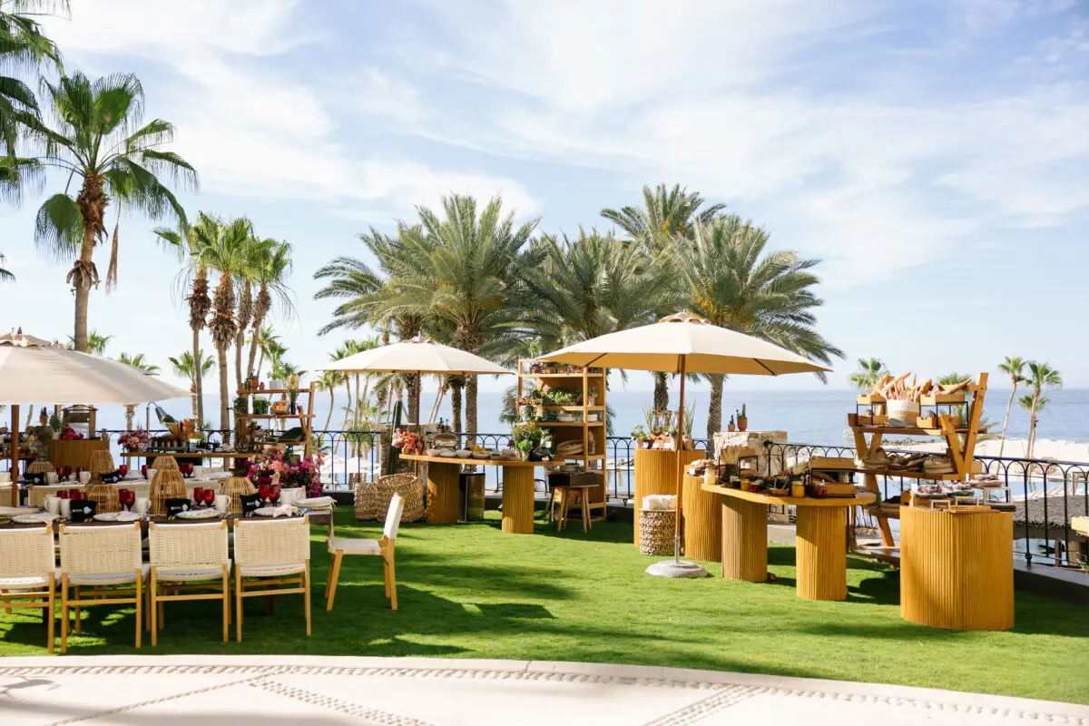 Los Cabos destination wedding setup at Hilton Los Cabos with tables, chairs, and palm trees.