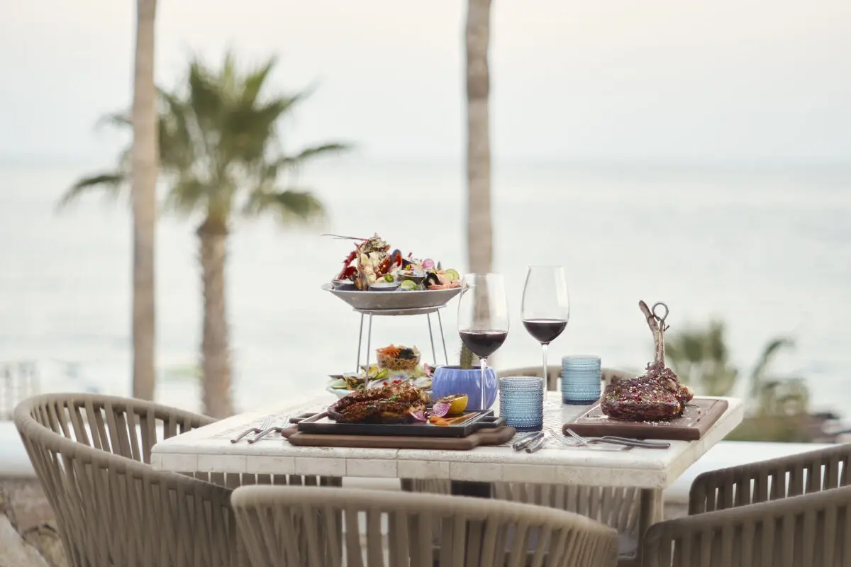 Los Cabos destination wedding feast with steak and seafood at Hilton Los Cabos overlooking the ocean.