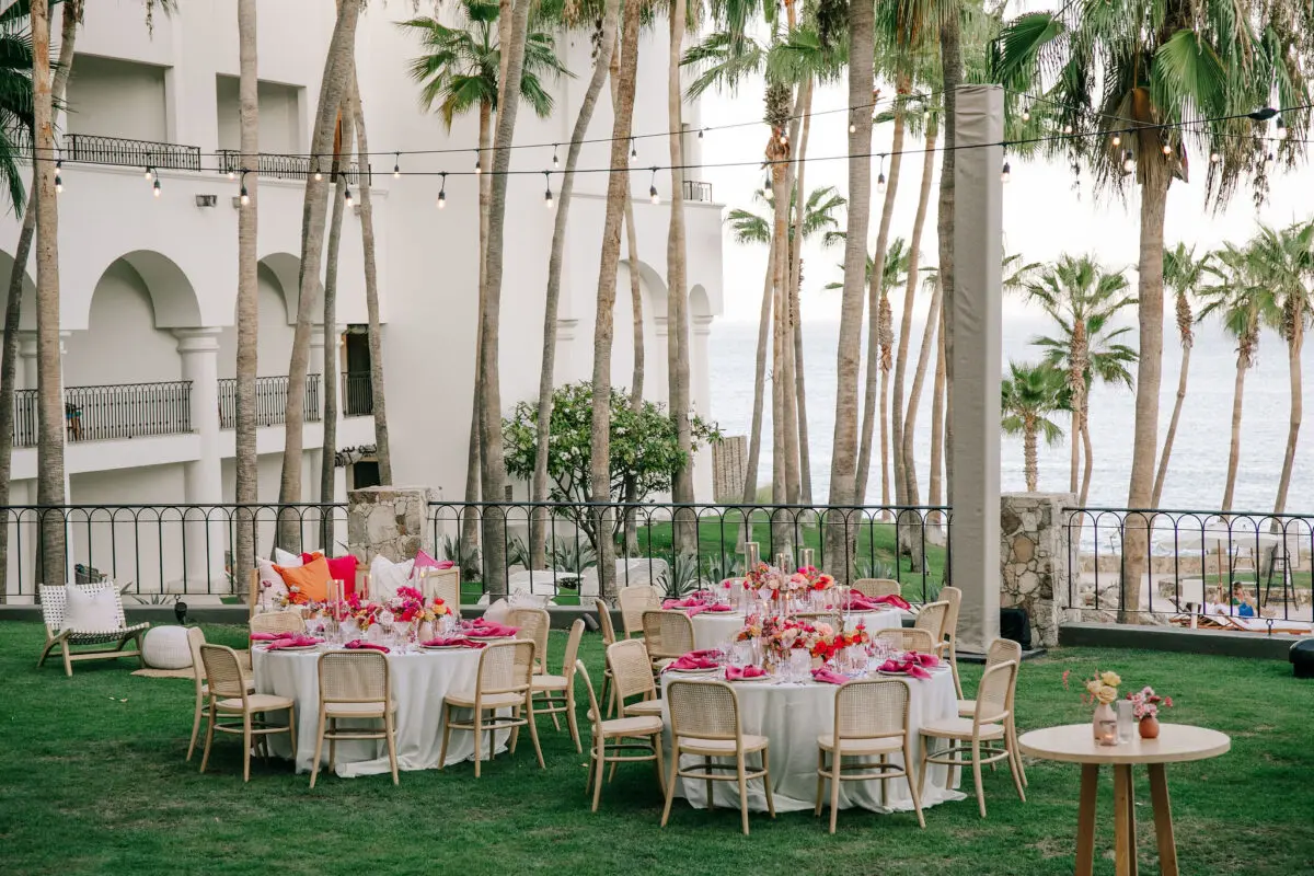 Los Cabos destination wedding reception at Hilton Los Cabos with round tables and palm trees.