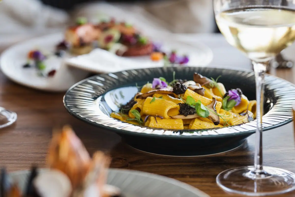 Gourmet pasta dish with mushrooms and edible flowers at Hilton Los Cabos. Los Cabos destination wedding.