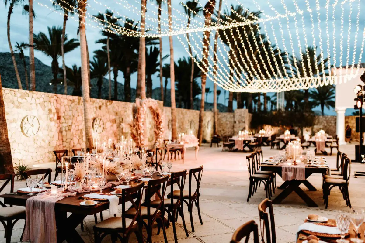 Los Cabos destination wedding reception at Hilton Los Cabos, with tables, chairs, and string lights at dusk.