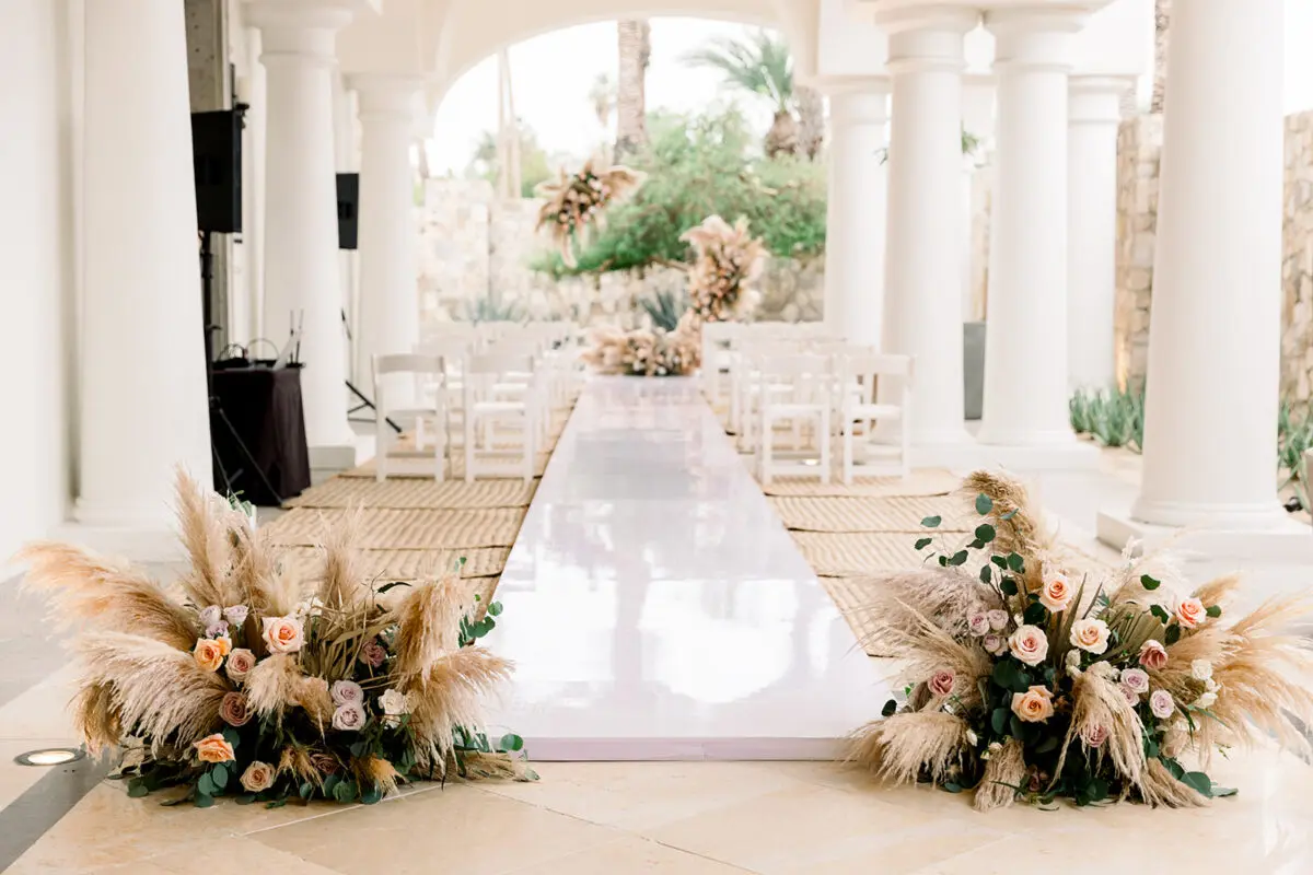 Los Cabos destination wedding ceremony setup with white aisle and floral arrangements at the Hilton Los Cabos.