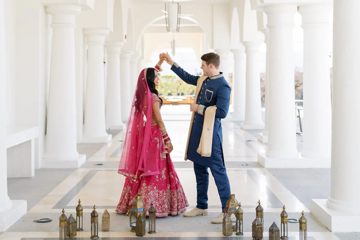 Los Cabos Destination Wedding at Hilton. Bride and groom under chandelier.