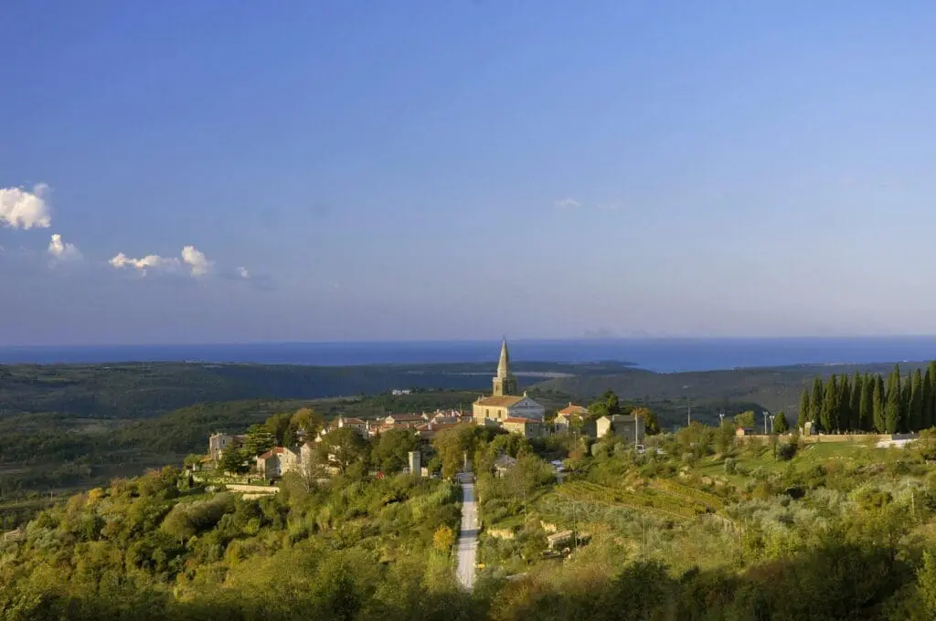 Istrian countryside with historic church and Adriatic Sea in the background