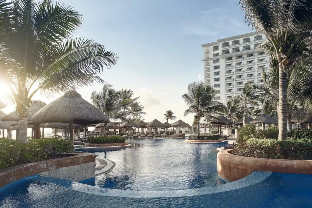 Resort pool and palm trees at beachfront wedding destination in Mexico