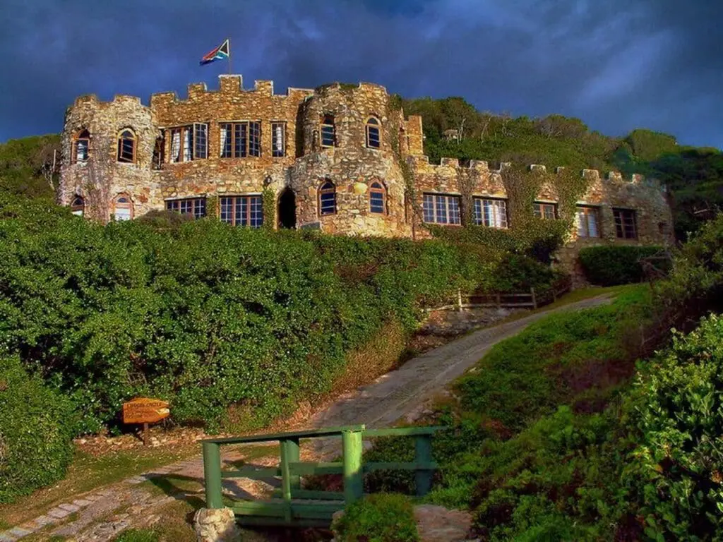 Stone castle wedding venue with a flag on top, surrounded by lush greenery. Perfect for a fairytale wedding.