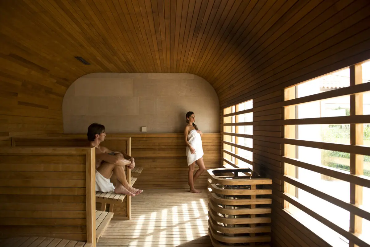 Couple relaxing in a wooden sauna at Relais Histò Hotel & SPA.