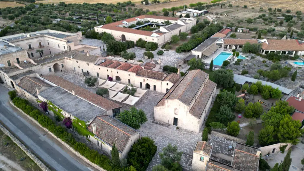 Aerial view of Relais Histò Hotel & SPA, showcasing its architecture, courtyard, pool, and surrounding landscape.
