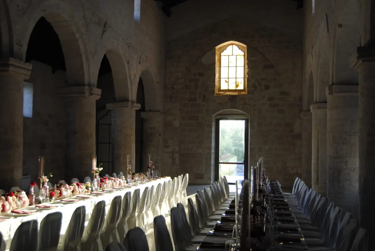 Elegant wedding reception setup at Relais Histò Hotel & SPA, featuring long tables and stone arches.