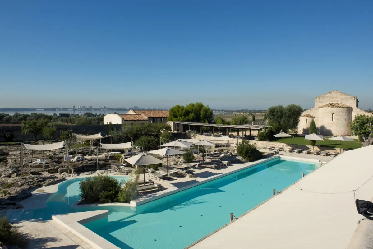 Relais Histò Hotel & SPA: Swimming pool, lounge chairs, and historic architecture under a clear blue sky.