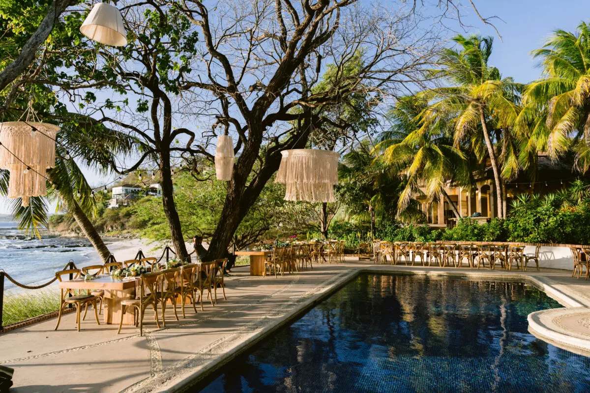 Rancho Santana wedding reception by the pool with macrame lanterns.