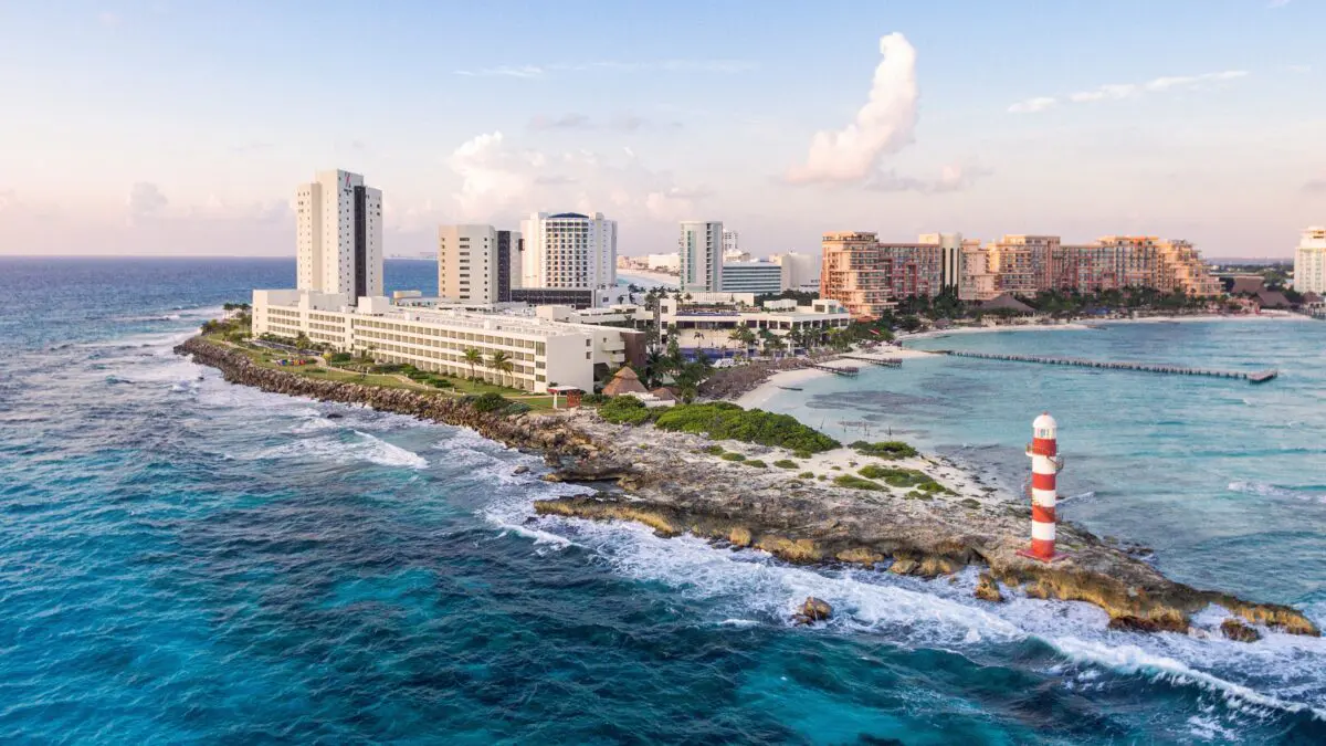 Hyatt Ziva Cancún aerial view featuring the beach, resort buildings, and a red and white lighthouse.