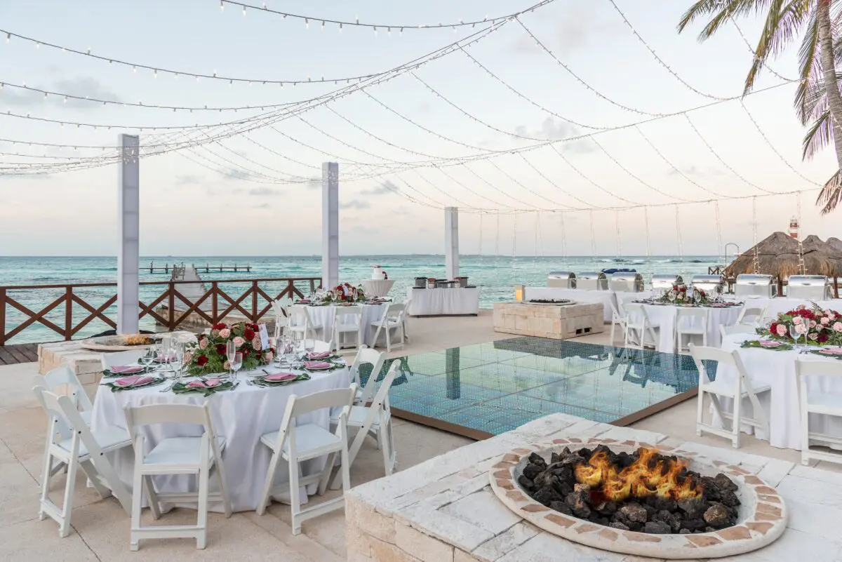 Luxury wedding venue in Cancun with lit fire pit and ocean view.