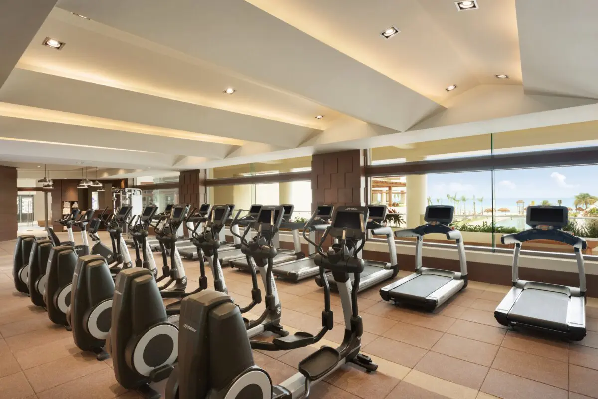 Hyatt Ziva Cancún gym with treadmills and elliptical machines, overlooking the ocean.