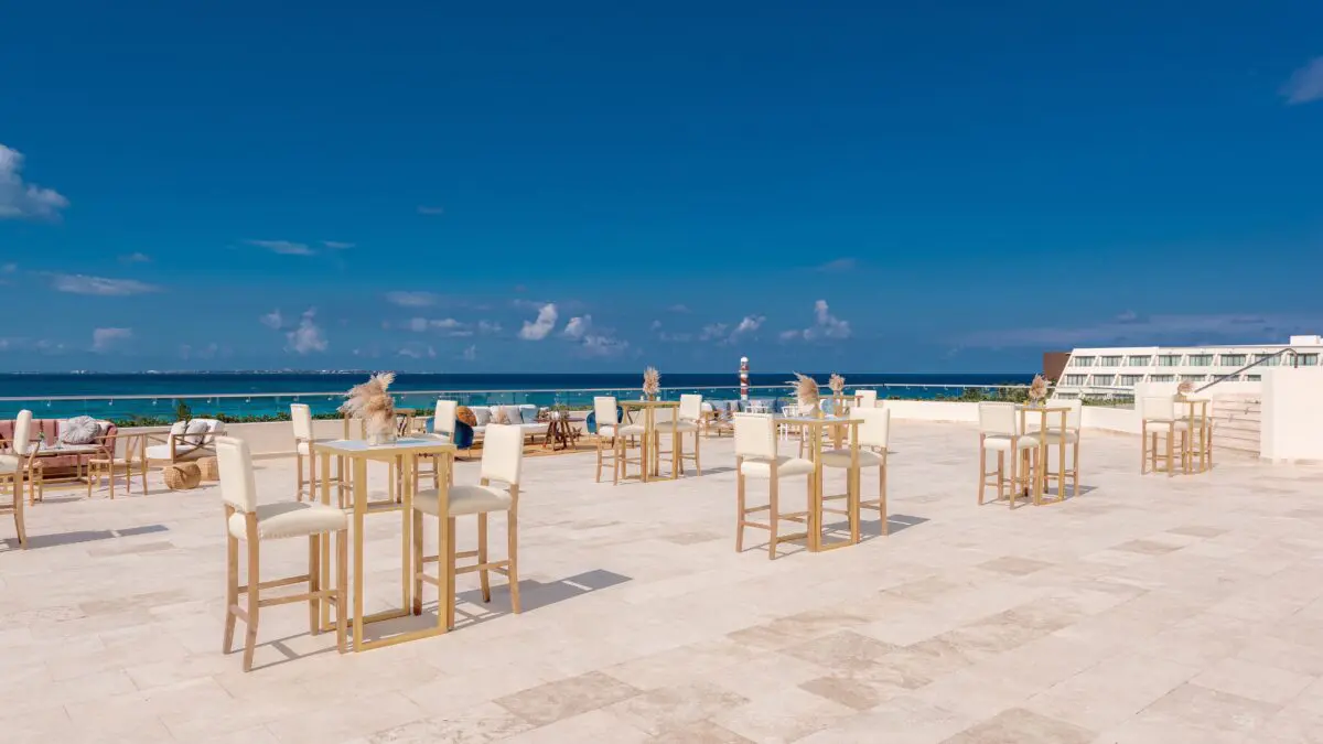 Luxury wedding venue in Cancun with ocean view and stylish cocktail tables.