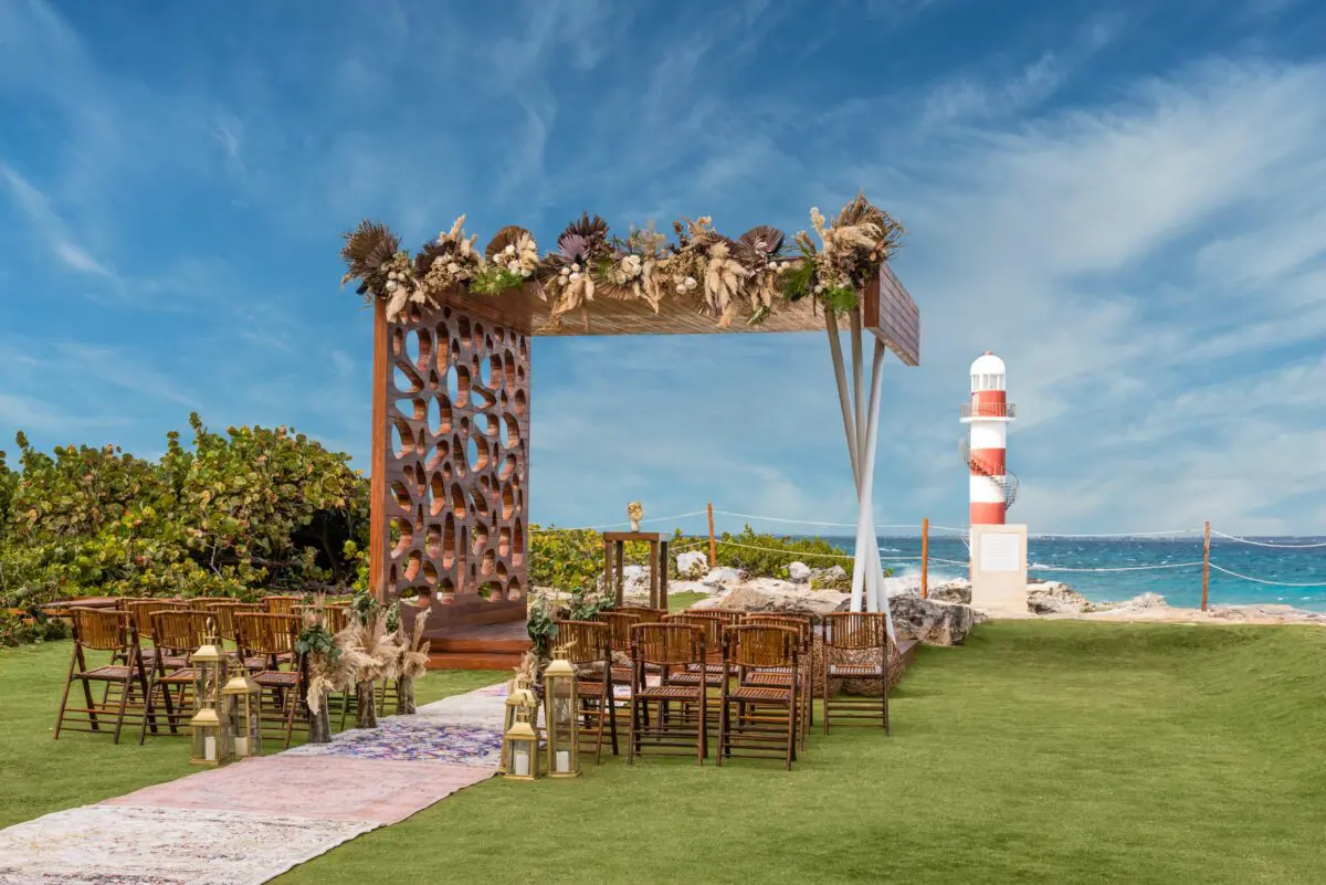 Luxury wedding venue in Cancun with decorated altar overlooking the ocean and lighthouse.