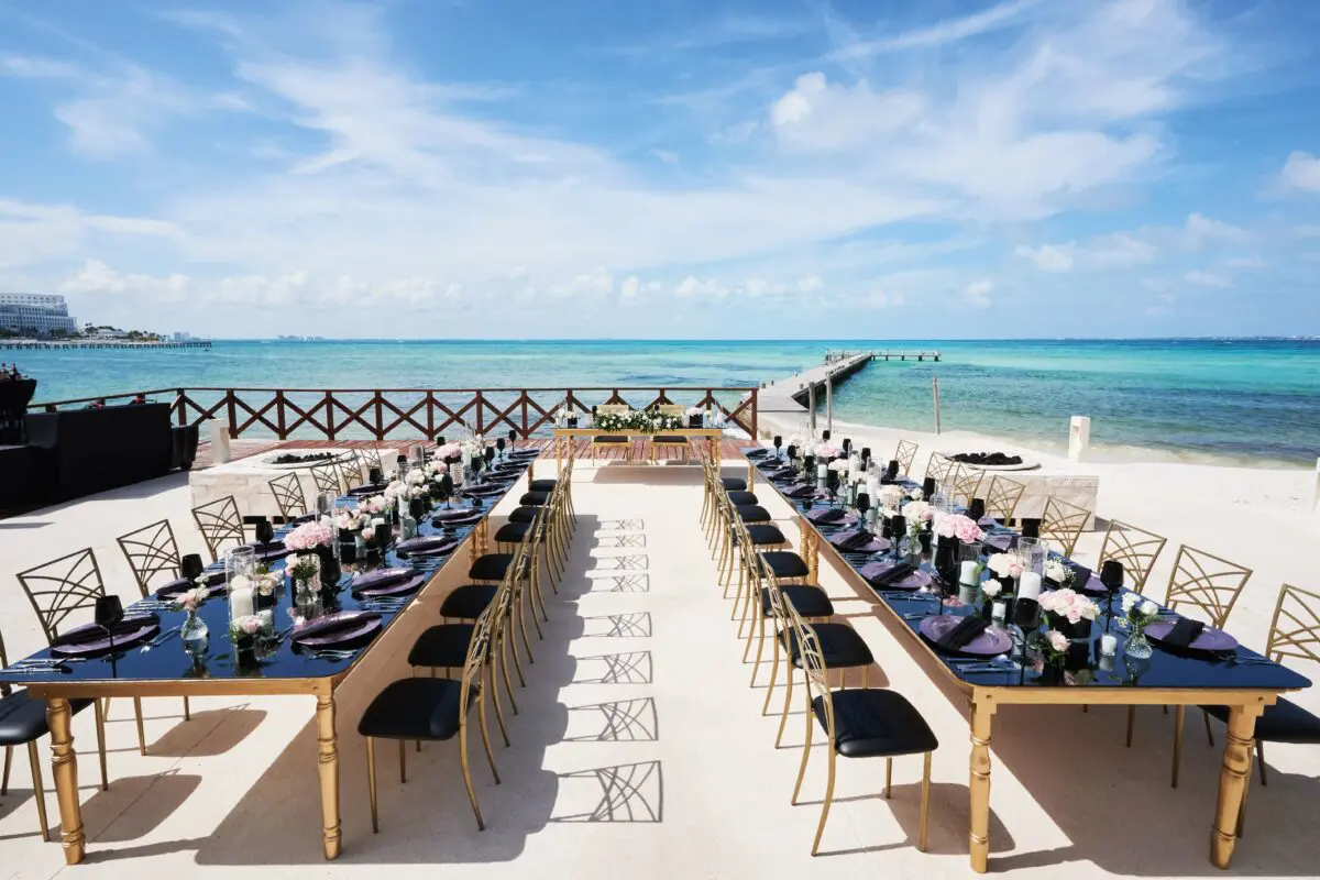 Luxury wedding venue in Cancun with long tables set on a beautiful beach.
