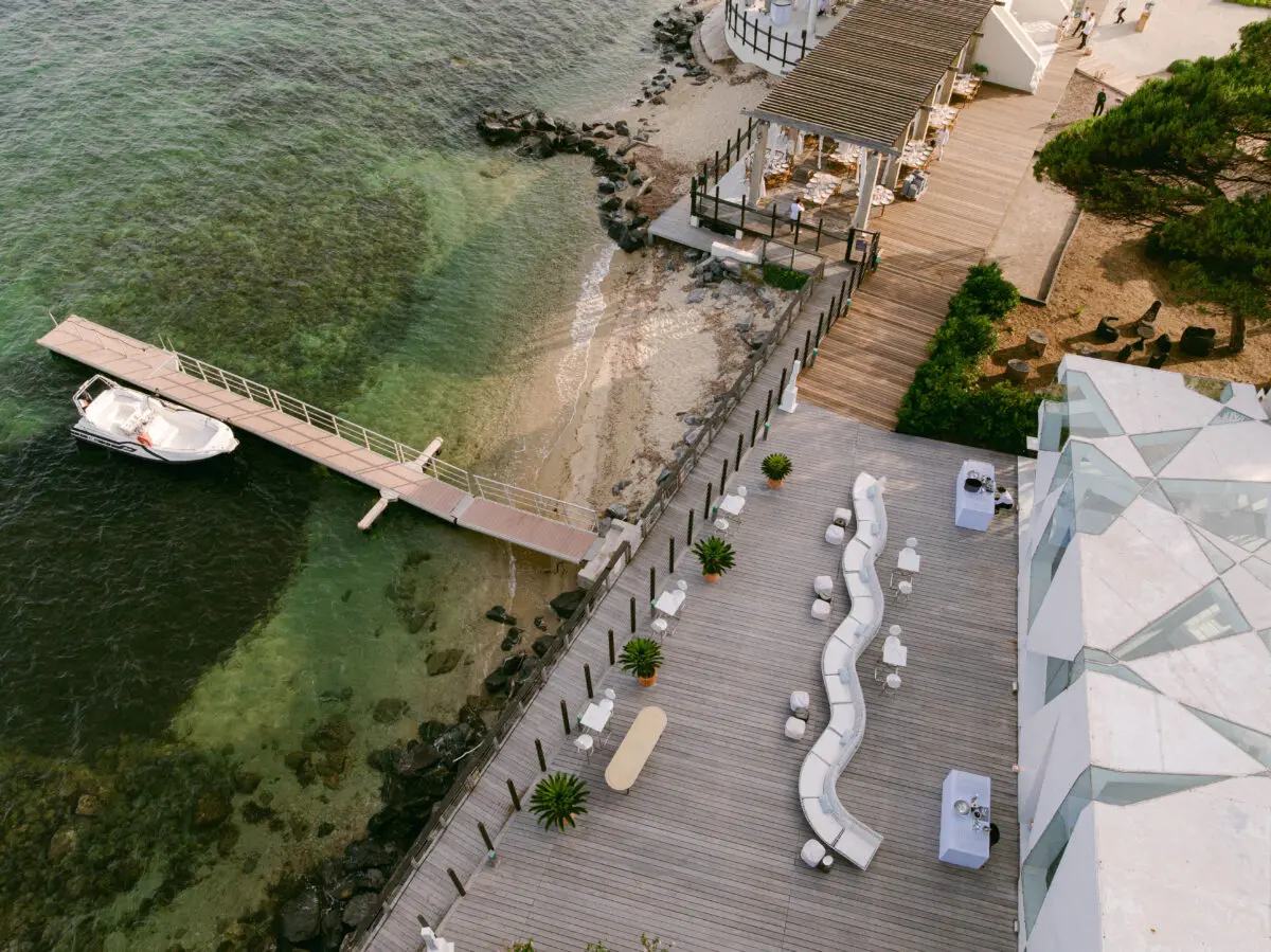 Aerial view of COMO Le Beauvallon, a venue for luxury weddings in Saint-Tropez, featuring a pier and outdoor seating.