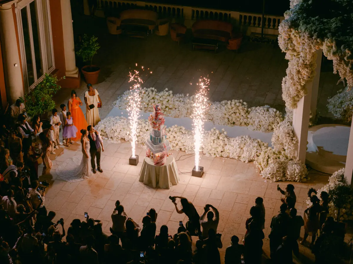 Luxury wedding in Saint-Tropez at COMO Le Beauvallon: Bride and groom with sparklers and multi-tiered cake.