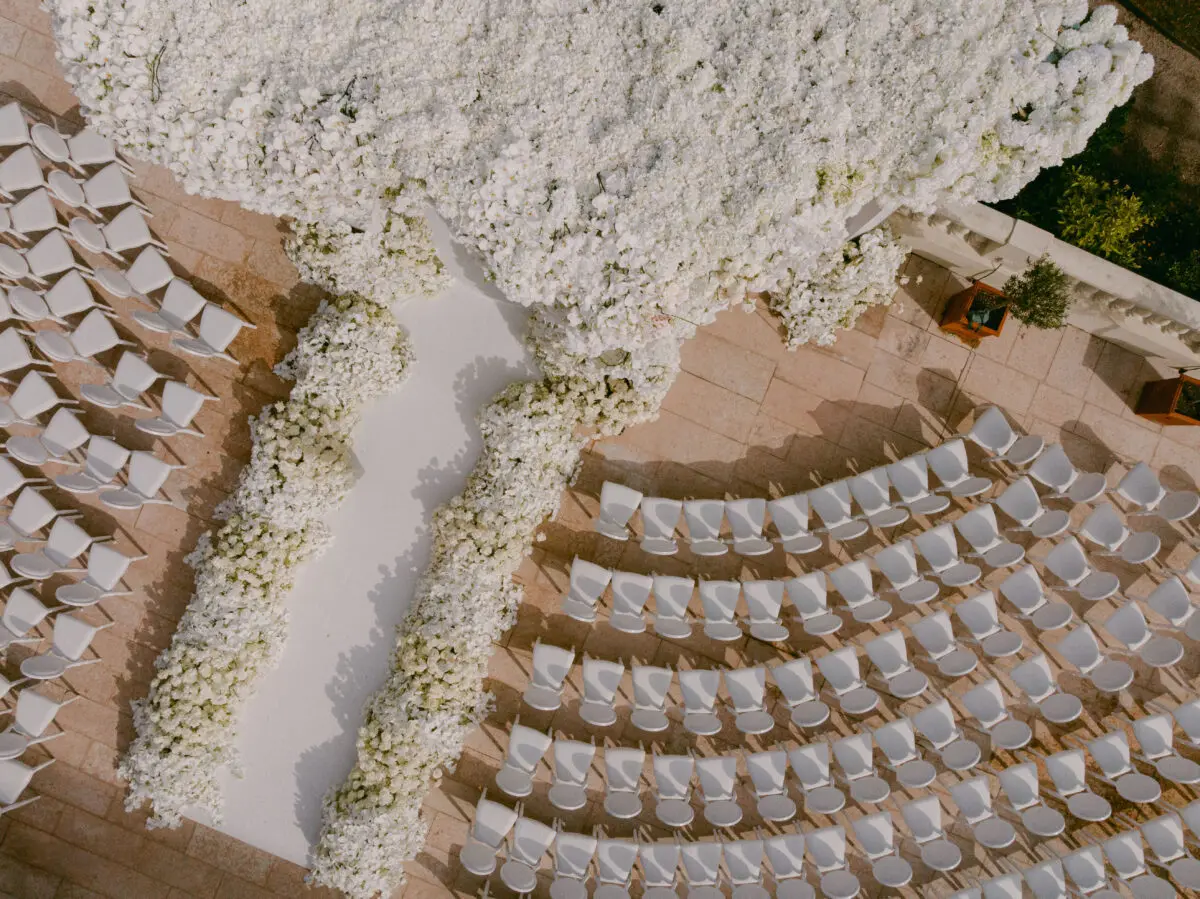 Luxury wedding in Saint-Tropez at COMO Le Beauvallon: Aerial view of white chairs and floral arch.
