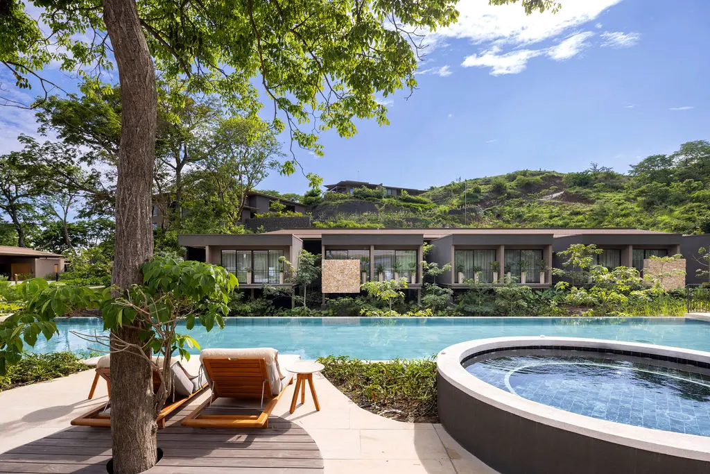 Waldorf Astoria Costa Rica: Luxurious pool area with lounge chairs and modern villas.