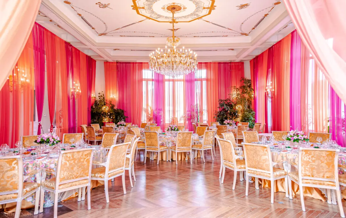 Luxury wedding in Saint-Tropez: Elegant reception room with round tables and chandelier.