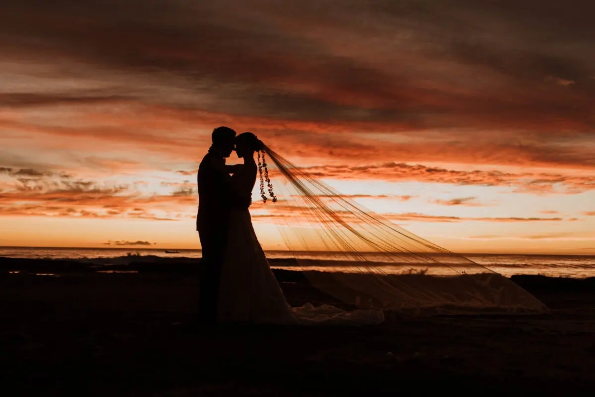 Silhouette of bride and groom embracing on a beach at sunset, Rancho Santana