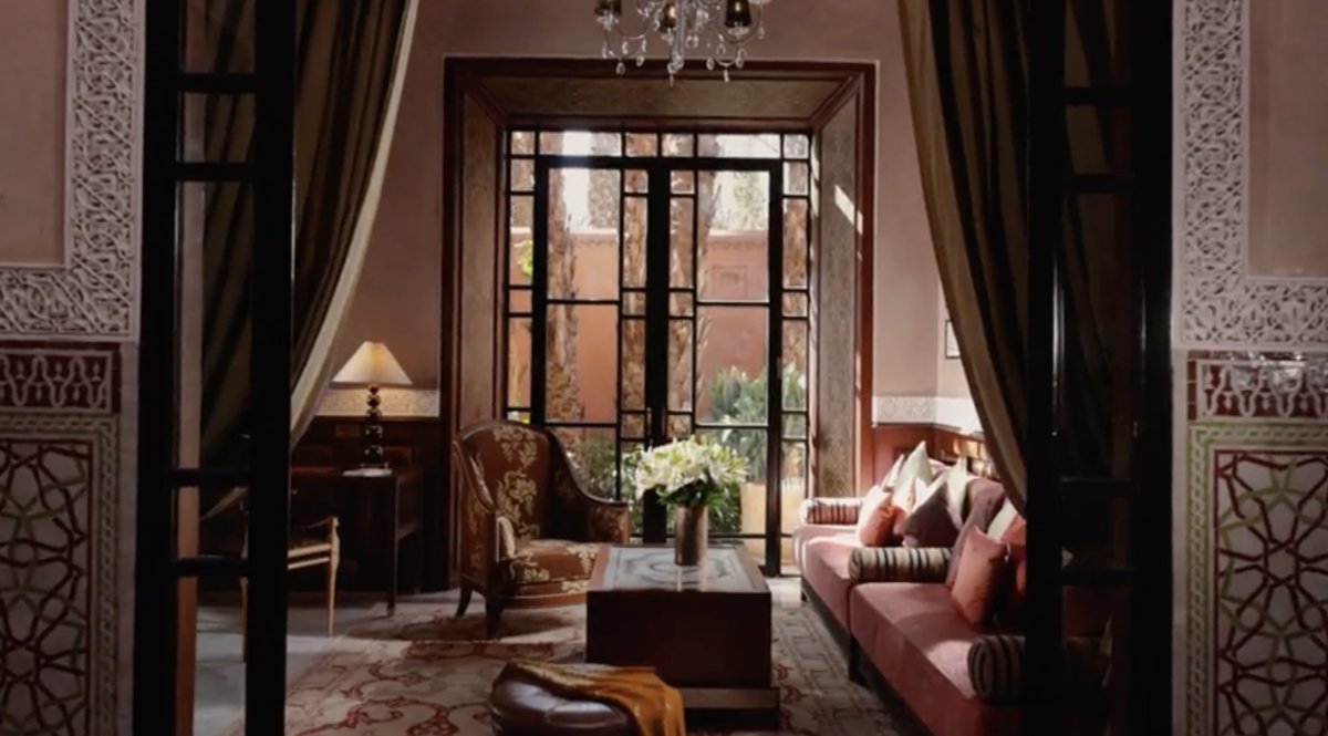Elegant luxury hotel room design with seating area, chandelier, and ornate tile details.