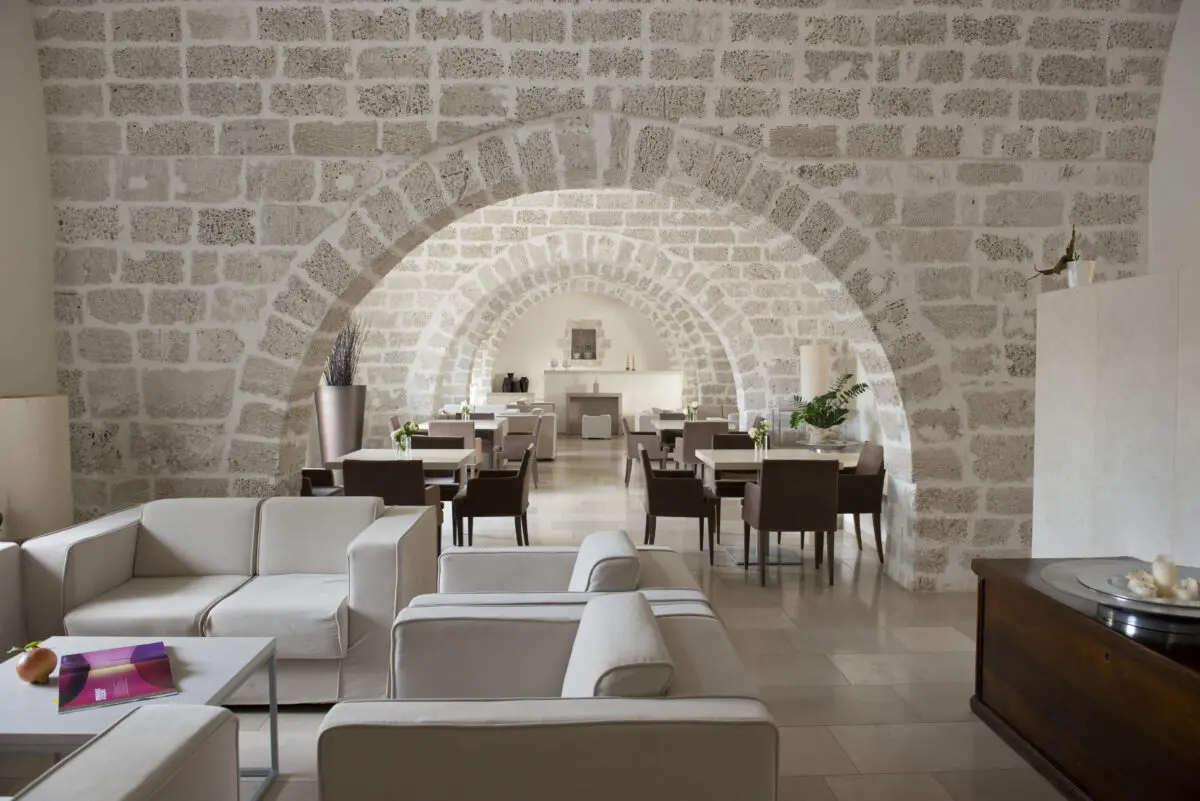 Relais Histò Hotel & SPA interior with stone arches, seating area, and dining tables.