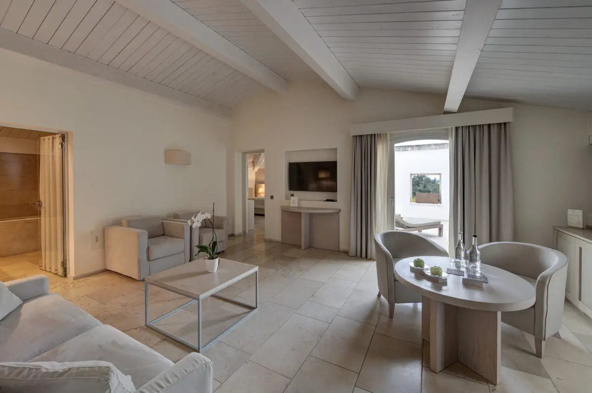 Relais Histò Hotel suite with sitting area, table, TV, and balcony view.