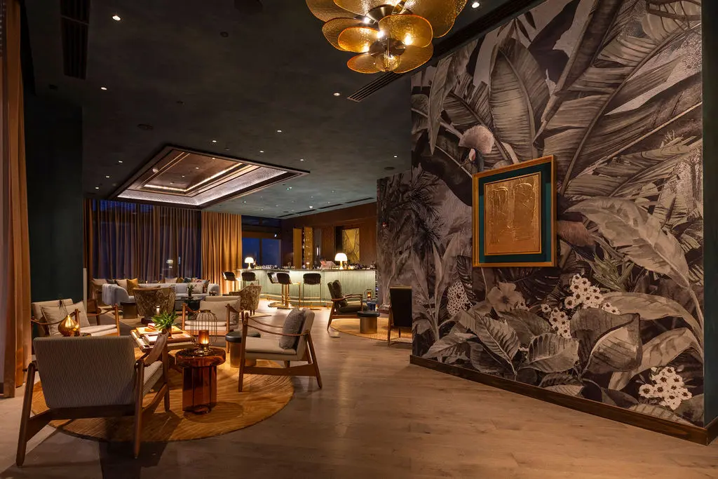 Waldorf Astoria Costa Rica lobby with tropical mural, stylish seating, and modern lighting.