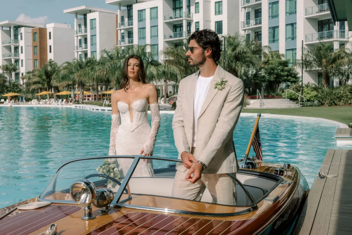 Elegant couple on a boat at a destination wedding resort, luxury setting.
