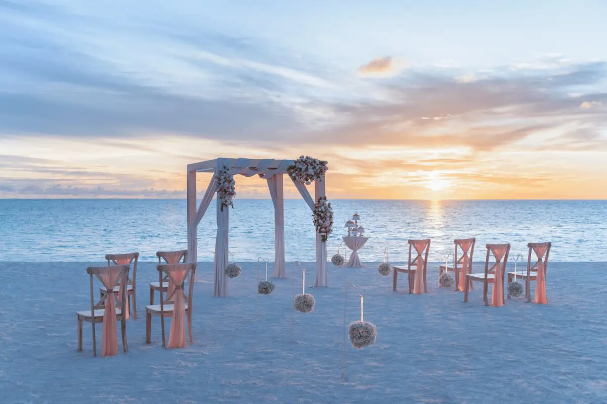 Beach wedding setup at sunset in Punta Cana, likely at one of the exclusive wedding resorts.