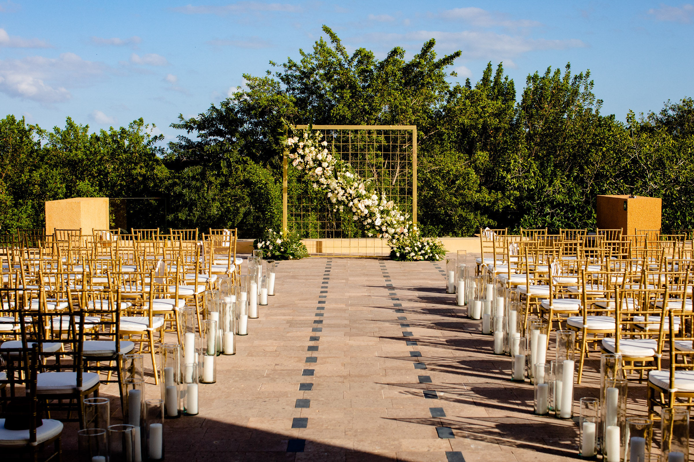 Riviera Maya ceremonies: Gold wedding arch with white flowers at Banyan Tree Mayakoba.