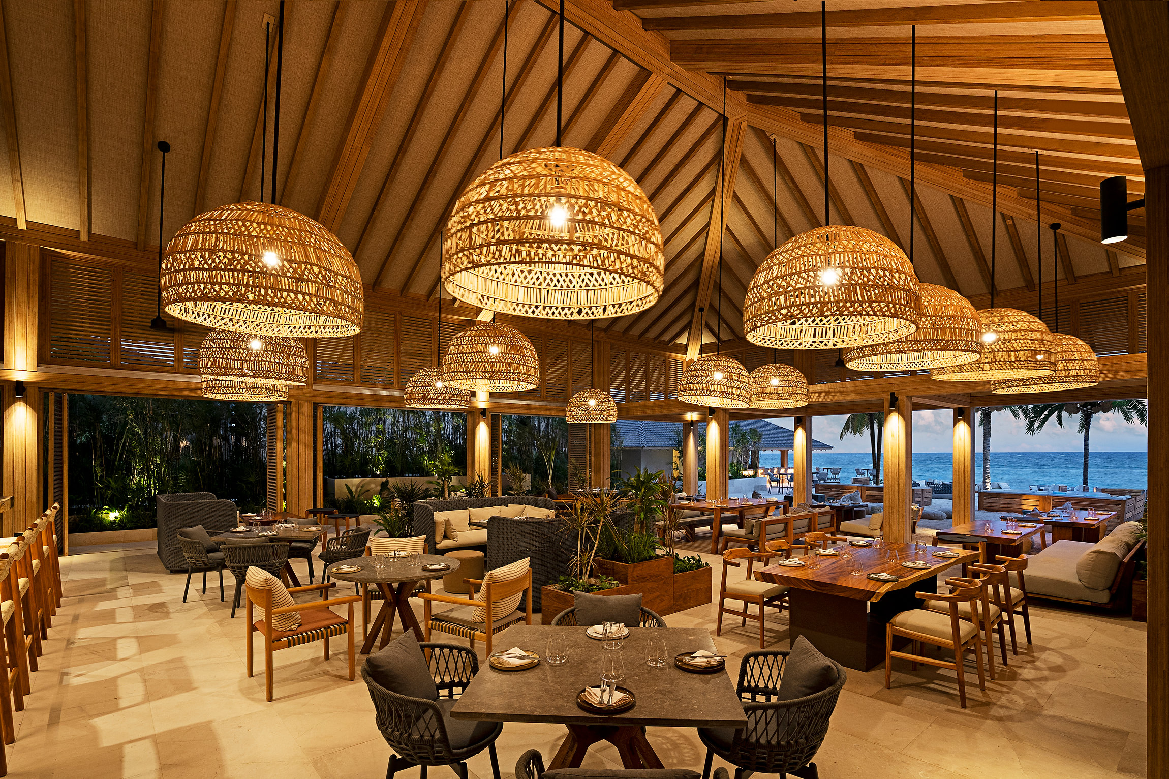 Banyan Tree Mayakoba's elegant restaurant with woven pendant lights and ocean views, perfect for Riviera Maya ceremonies.