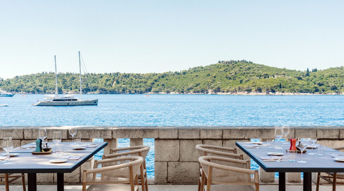 Outdoor dining at Villa Dubrovnik, Croatia, with sea view and yacht. Destination wedding hotel.