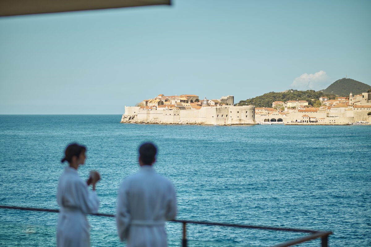 Couple in robes overlooking Dubrovnik, Croatia. Possible destination wedding hotel view.