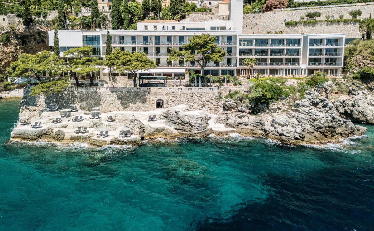 Villa Dubrovnik, a Croatia destination wedding hotel, overlooks the turquoise Adriatic Sea from a rocky coastline.