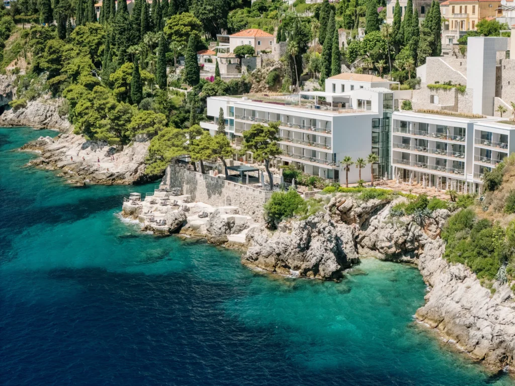 Villa Dubrovnik, a Croatia destination wedding hotel, sits on a rocky coastline with turquoise water.