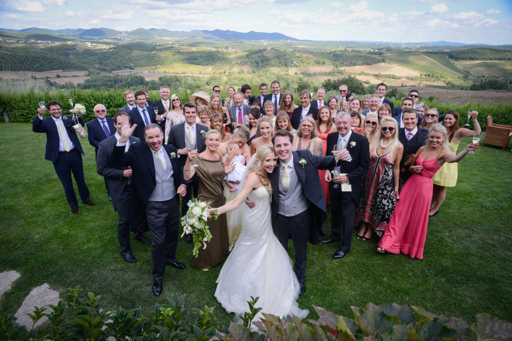 Bride & groom with wedding guests posing and cheering