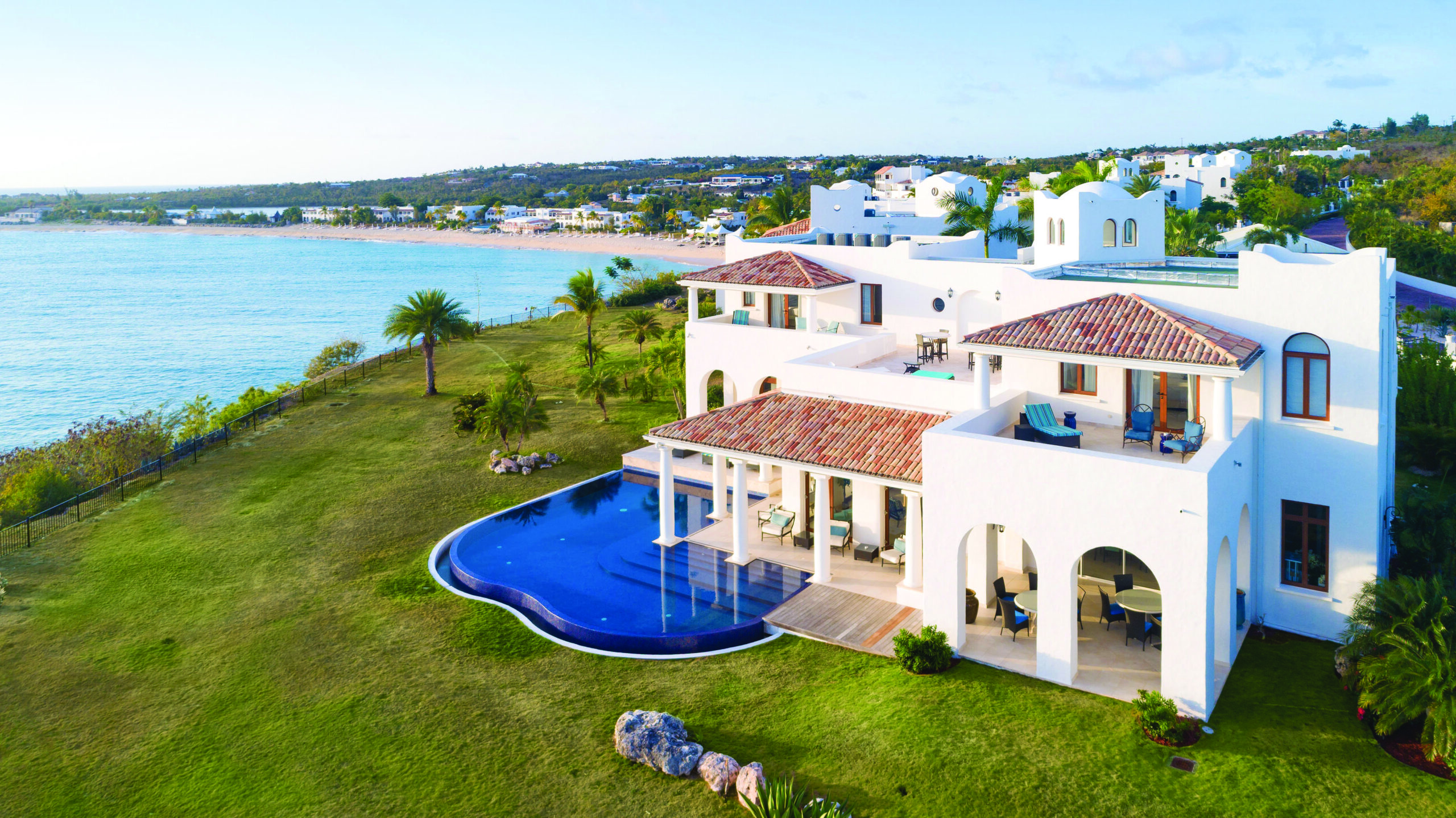 Luxury villa with pool overlooking a beach, ideal wedding location.