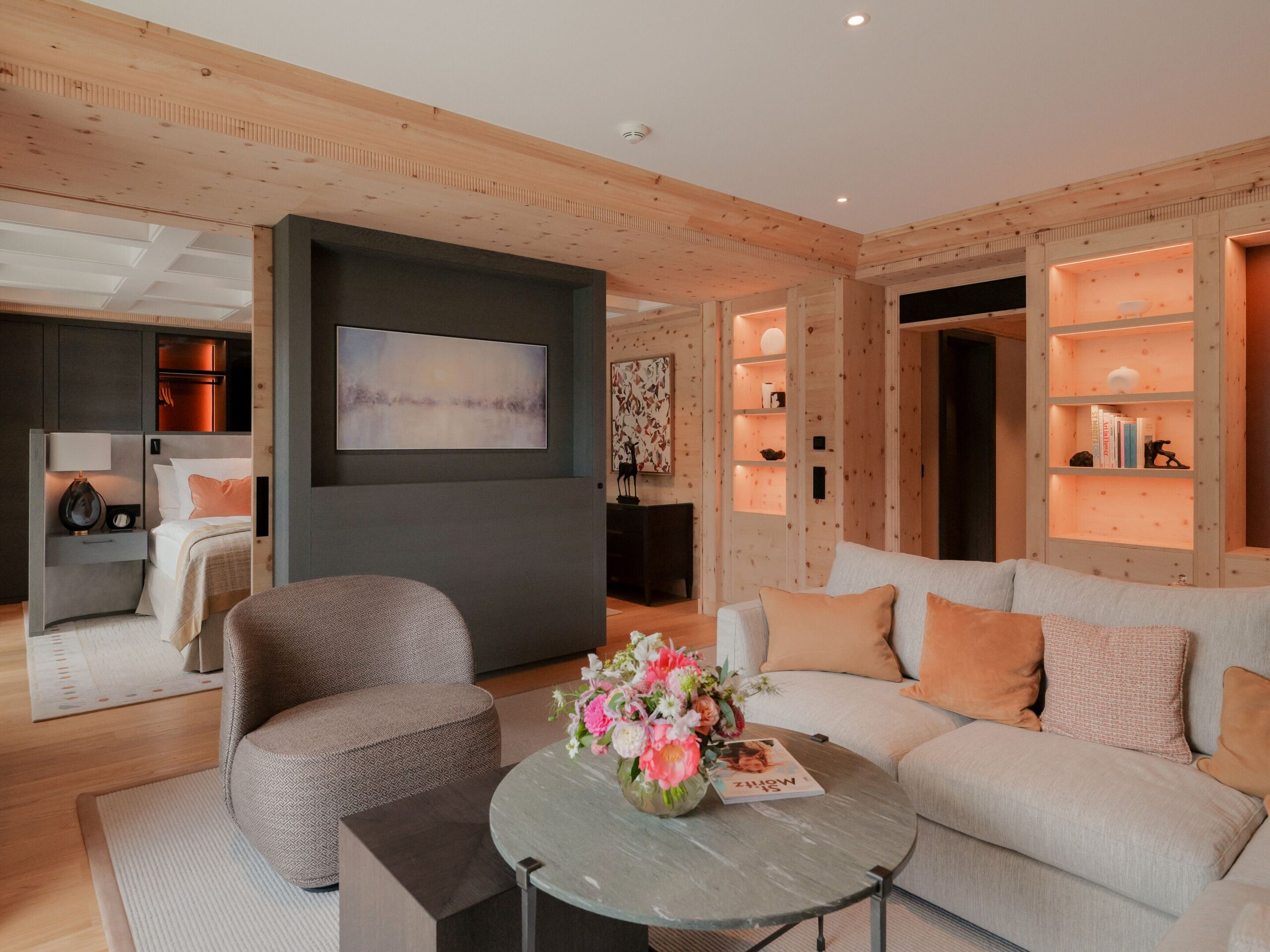Kulm Hotel St. Moritz suite with wood paneling, a sofa, and a view into the bedroom.