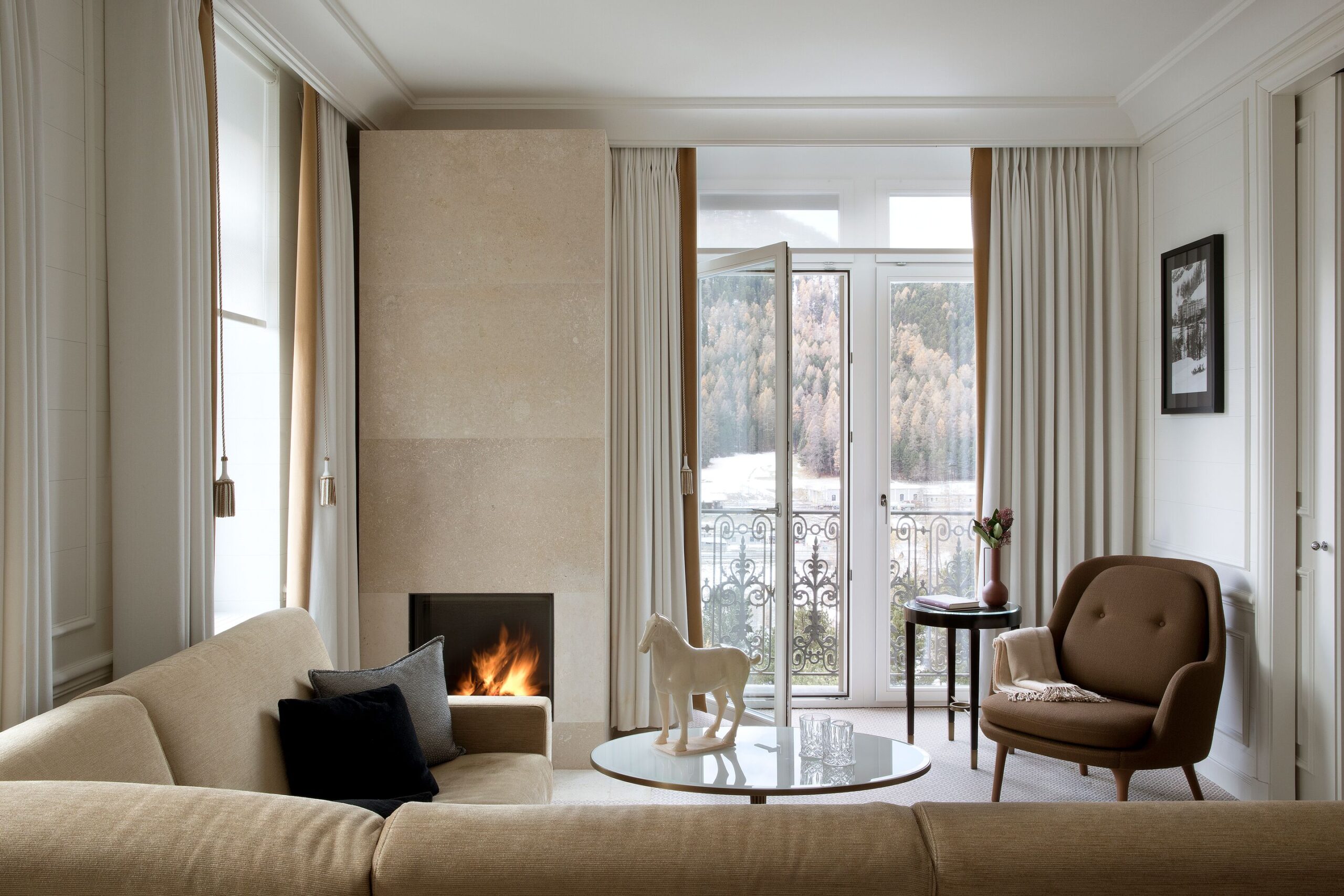 Grand Hotel Kronenhof suite with fireplace, sofa, and balcony overlooking the Swiss Alps.