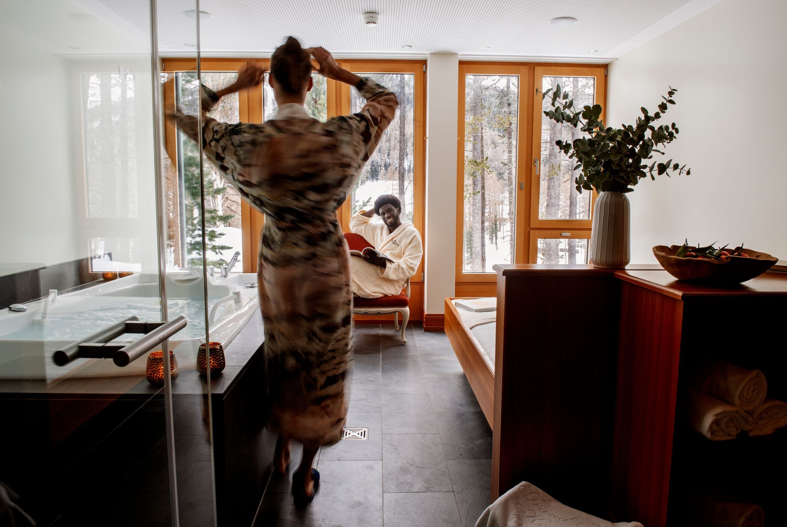 Couple relaxing at Grand Hotel Kronenhof spa with snowy Swiss Alps view.