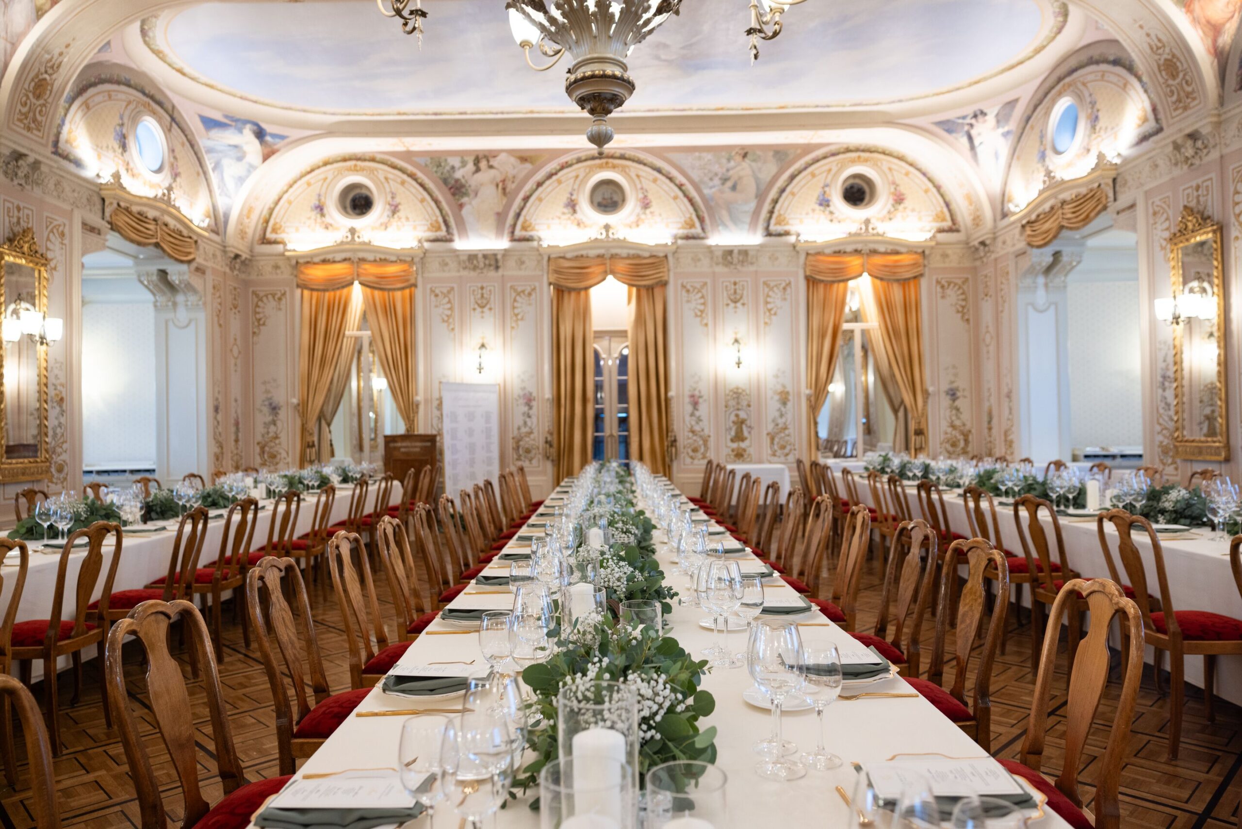 Elegant wedding reception setup at the Grand Hotel Kronenhof in the Swiss Alps. Long table with floral centerpiece.