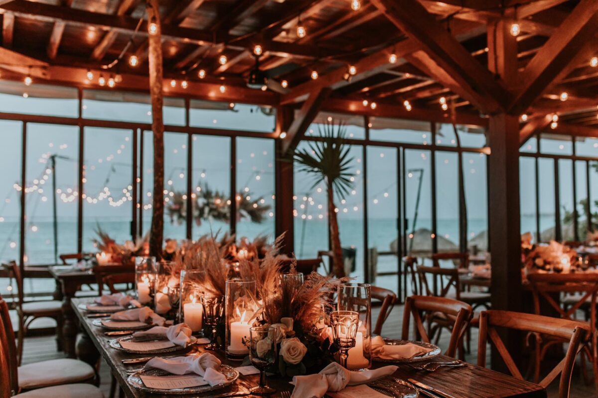 Elegant wedding reception at Jashita Hotel, Tulum. Tables are set with candles and flowers on the beach.