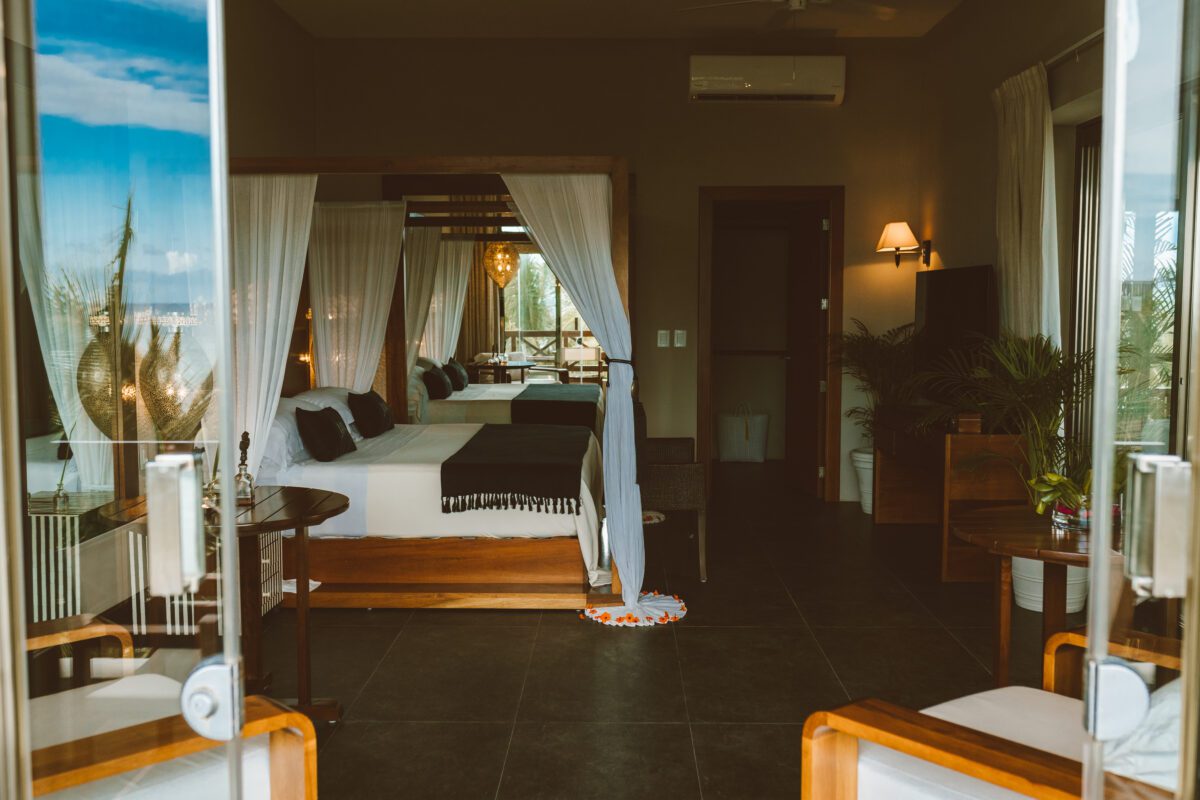 Jashita Hotel Tulum suite with canopy bed and open doors to a patio. Ideal Tulum wedding venue.